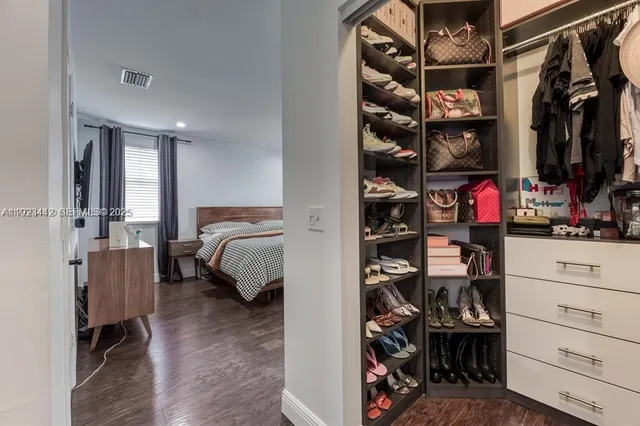a view of walk in closet with clothes and shoes