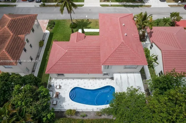 an aerial view of a house with swimming pool and patio