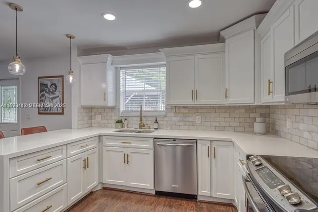 a kitchen with white cabinets sink and white appliances