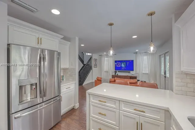 a kitchen with stainless steel appliances granite countertop a refrigerator and a sink