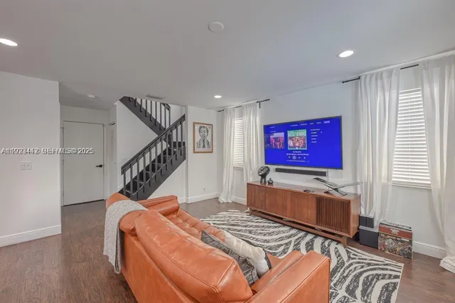 a living room with furniture windows and wooden floor