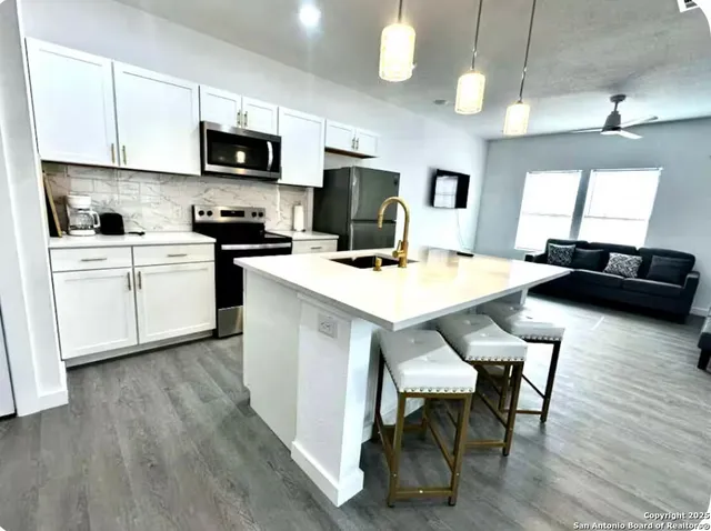 a kitchen with a table chairs microwave and cabinets