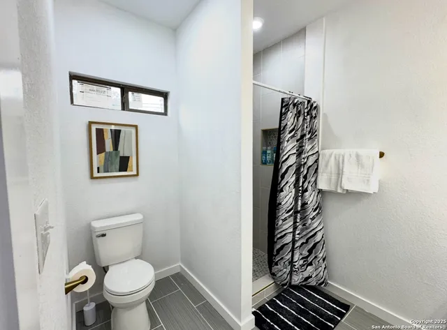 a bathroom with a toilet and a shower curtain