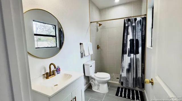 a bathroom with a sink toilet and shower