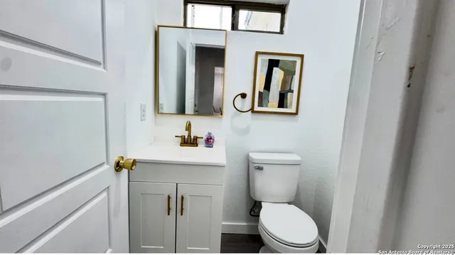 a bathroom with a toilet a sink and mirror