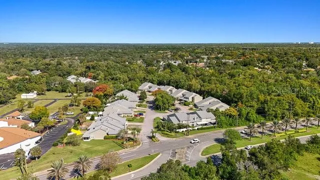 an aerial view of residential houses with outdoor space and trees