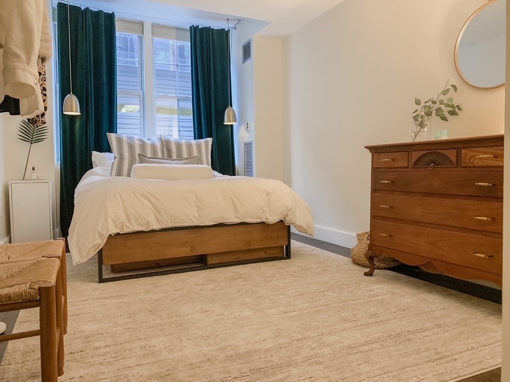 200 Market Street, Unit 3010 Lowell, MA 01852 - Photo 15 of 26 a spacious bedroom with a bed and a mirror