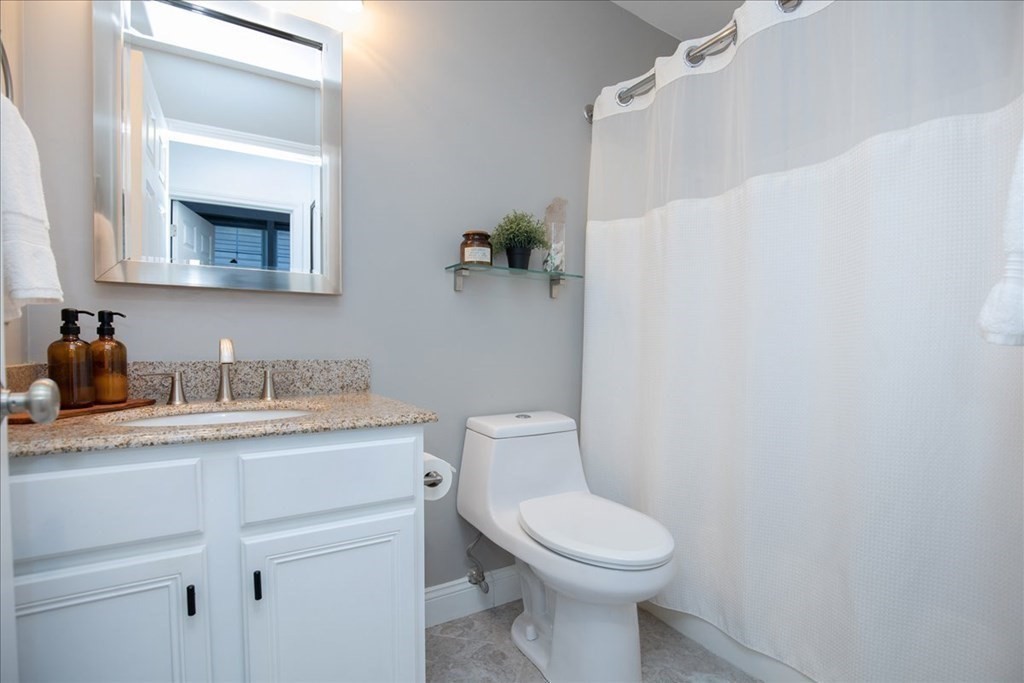 200 Market Street, Unit 3010 Lowell, MA 01852 - Photo 17 of 26 a bathroom with a granite countertop toilet sink and mirror