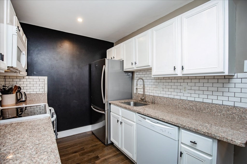 200 Market Street, Unit 3010 Lowell, MA 01852 - Photo 6 of 26 a kitchen with stainless steel appliances granite countertop a sink stove and refrigerator