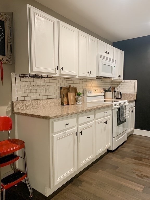 200 Market Street, Unit 3010 Lowell, MA 01852 - Photo 9 of 26 a kitchen with granite countertop white cabinets and white appliances