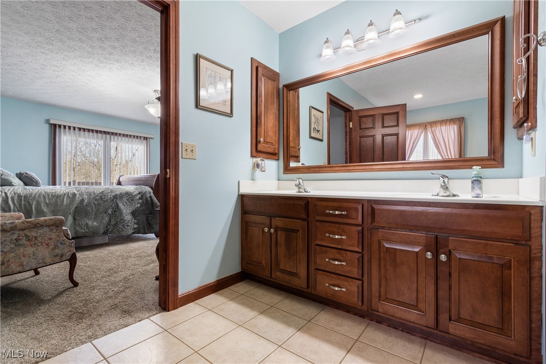 3393 Friendsville Road Wooster, OH 44691 - Photo 15 of 34 Bathroom featuring double vanity, a sink, and tile patterned floors
