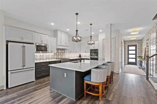a kitchen with granite countertop a sink appliances a counter space and a dining table