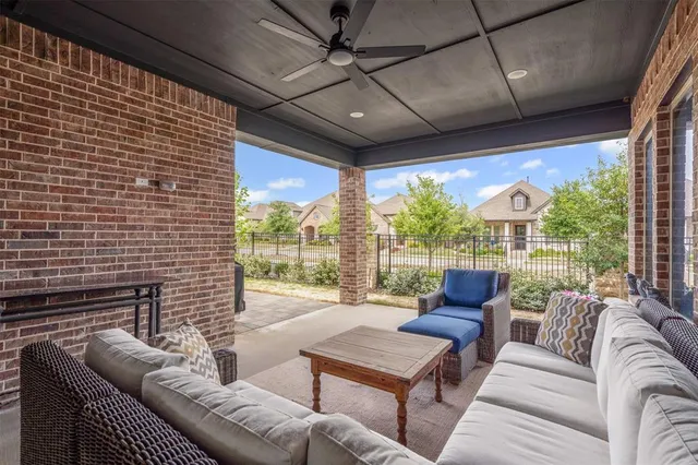 a living room with furniture a ceiling fan and a floor to ceiling window