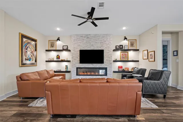 a living room with furniture kitchen view and a flat screen tv