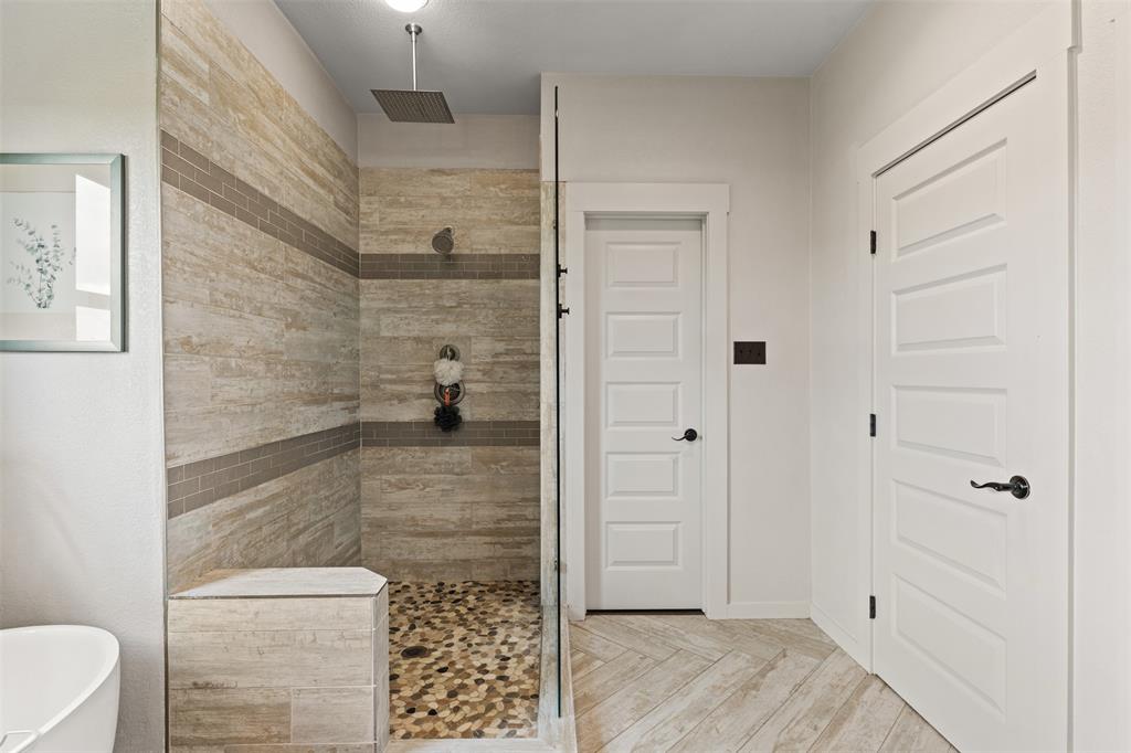 124 Bluffview Circle China Spring, TX 76633 - Photo 26 of 40 Walk-in shower with natural-toned stone tile walls and horizontal accent bands