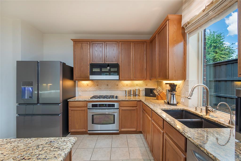 11601 Forestbrook Drive Frisco, TX 75035 - Photo 11 of 40 a kitchen with a sink stove and refrigerator