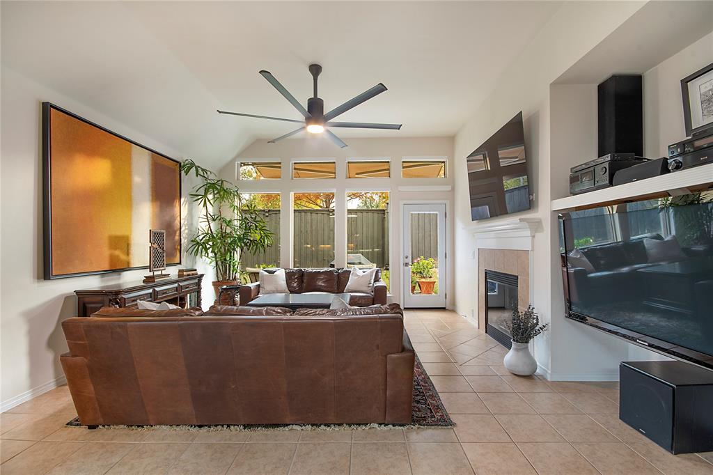 11601 Forestbrook Drive Frisco, TX 75035 - Photo 16 of 40 a living room with furniture a fireplace and a flat screen tv
