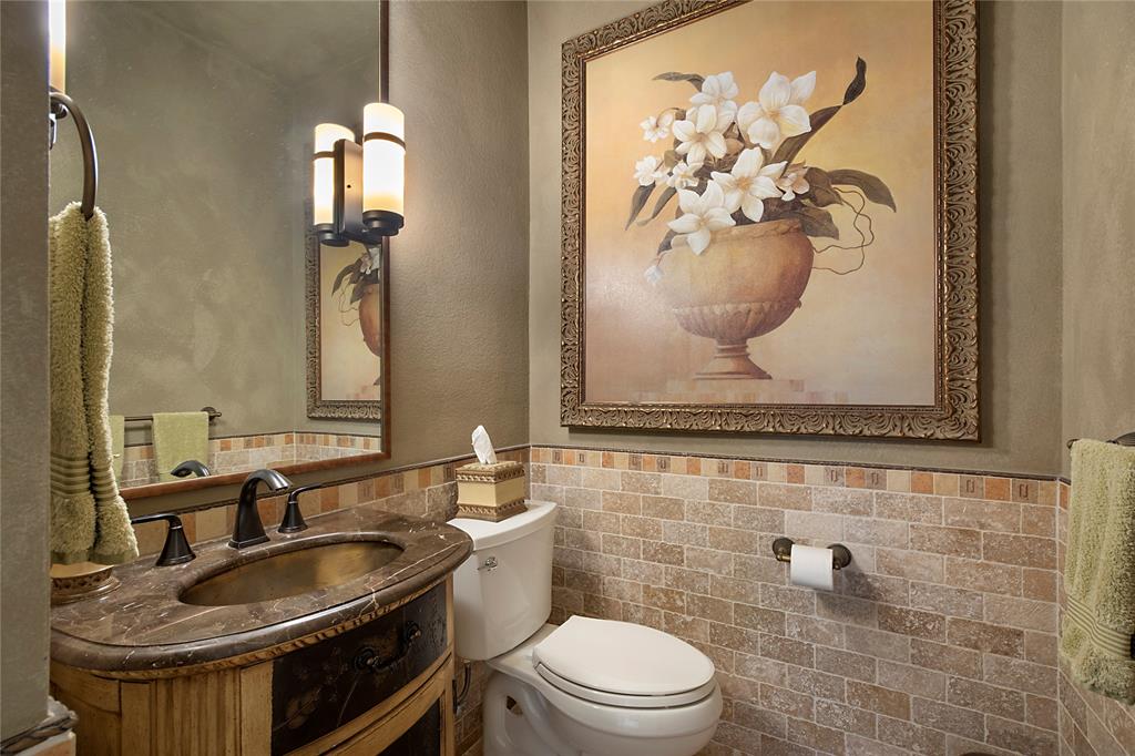 11601 Forestbrook Drive Frisco, TX 75035 - Photo 20 of 40 a bathroom with a granite countertop sink a toilet and a mirror