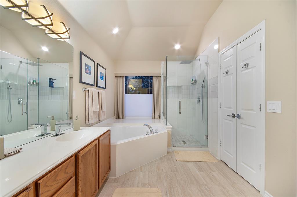 11601 Forestbrook Drive Frisco, TX 75035 - Photo 34 of 40 a spacious bathroom with a shower a sink and a mirror
