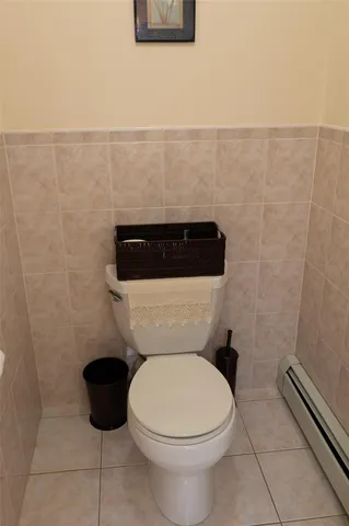 a white toilet sitting next to a white wall