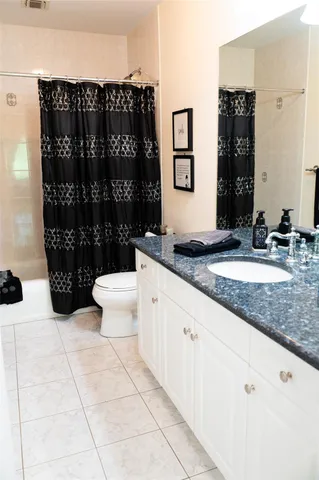 a bathroom with a sink a toilet a mirror and shower