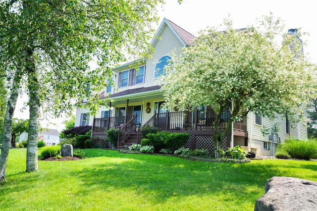 a view of a house with a yard and potted plants