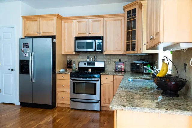 a kitchen with stainless steel appliances granite countertop a refrigerator stove and sink