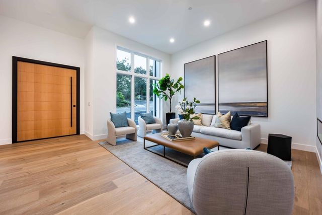 a living room with furniture potted plant and a large window