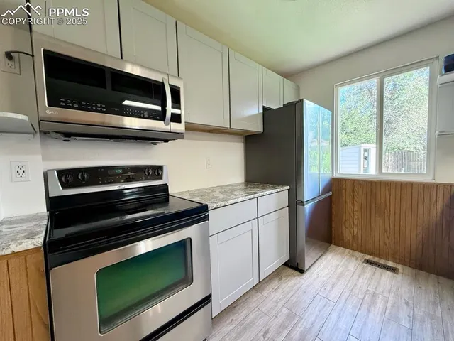 a kitchen with wooden cabinets and stainless steel appliances