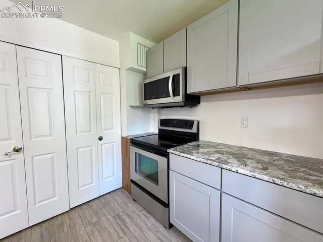 a kitchen with stainless steel appliances granite countertop a stove a sink and a microwave