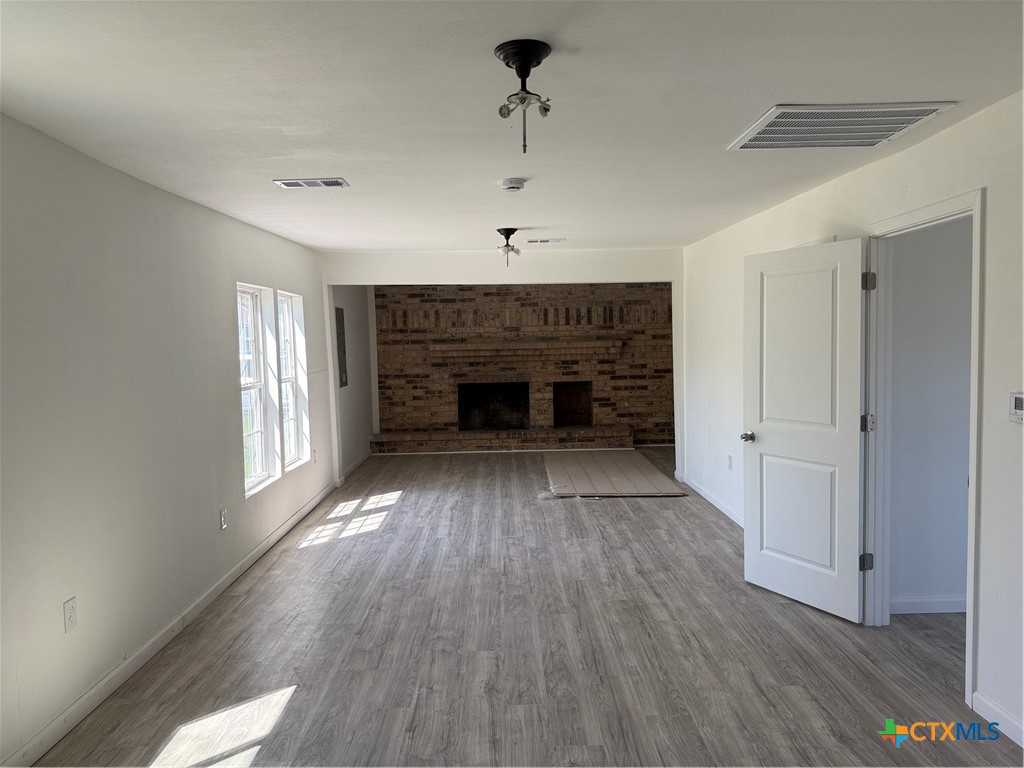 2411 Mumphord Street Victoria, TX 77901 - Photo 5 of 17 a view of an empty room with wooden floor fireplace and a window