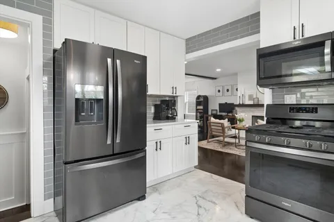 a kitchen with stainless steel appliances granite countertop a refrigerator stove and microwave