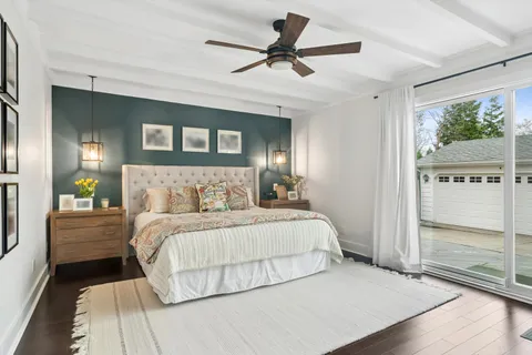 a bedroom with a large bed chandelier and a window