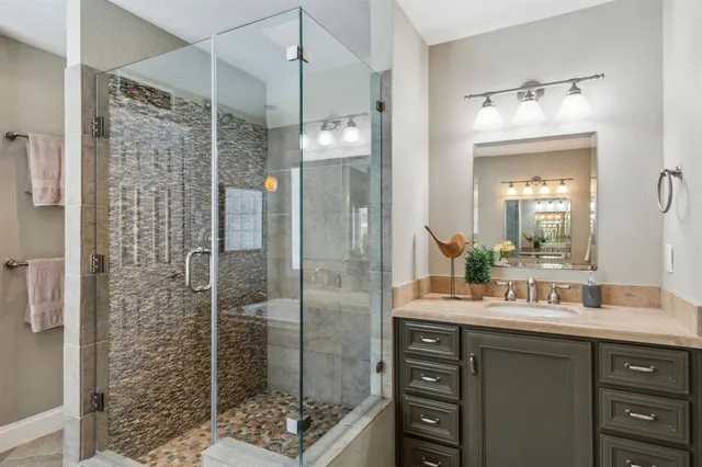 a bathroom with a shower sink and mirror