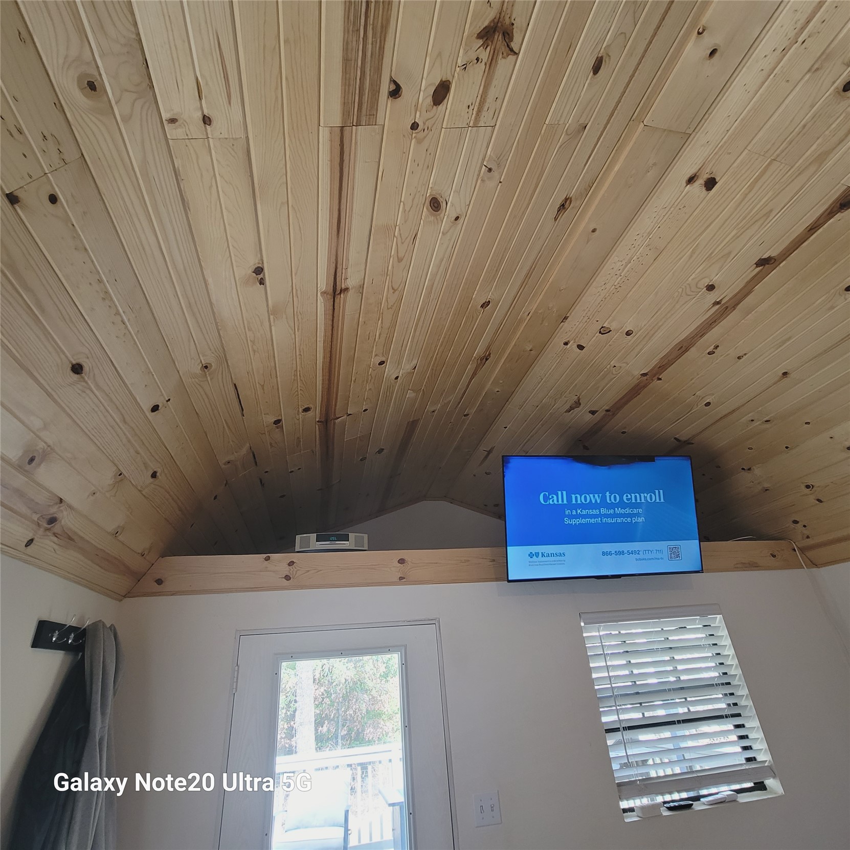 115 Locust Road Stigler, OK 74462 - Photo 28 of 29 Vaulted wood-paneled ceiling, white interior walls, built-in shelf, white door with glass panel, and a window with blinds