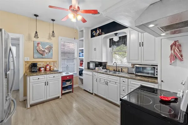 a kitchen with stainless steel appliances granite countertop a stove refrigerator and cabinets