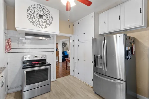 a kitchen with stainless steel appliances a refrigerator stove and cabinets
