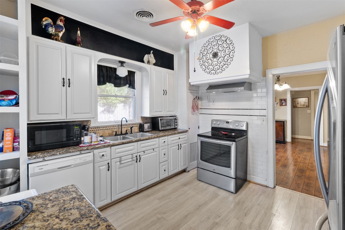 205 Jephson Street Alvin, TX 77511 - Photo 15 of 40 a kitchen with stainless steel appliances granite countertop a stove a sink and a microwave