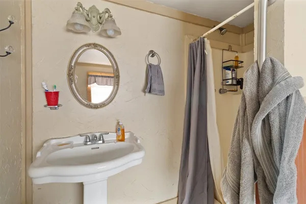 a bathroom with a sink a mirror a vanity and a shower