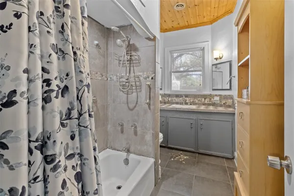 a bathroom with a granite countertop sink a toilet and shower