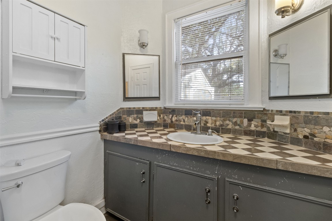 205 Jephson Street Alvin, TX 77511 - Photo 7 of 40 a bathroom with a granite countertop sink a toilet and a window