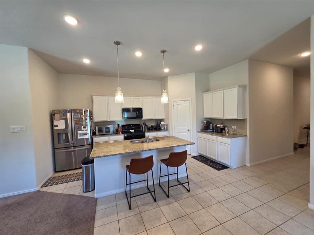 1512 Springtree Drive McKinney, TX 75071 - Photo 6 of 23 a kitchen with refrigerator and chairs