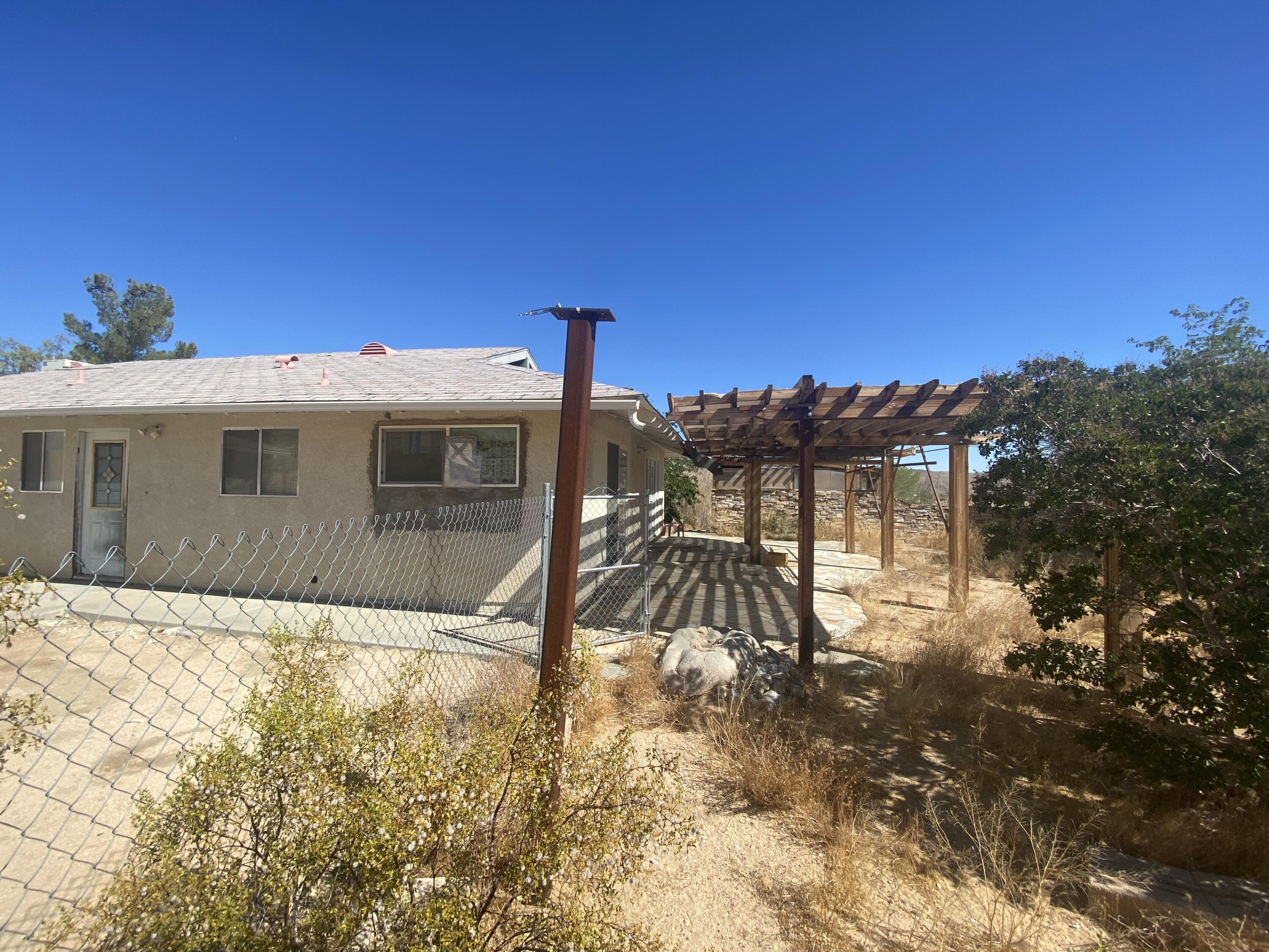 6784 Outpost Road Joshua Tree, CA 92252 - Photo 2 of 22 a view of a house with a yard