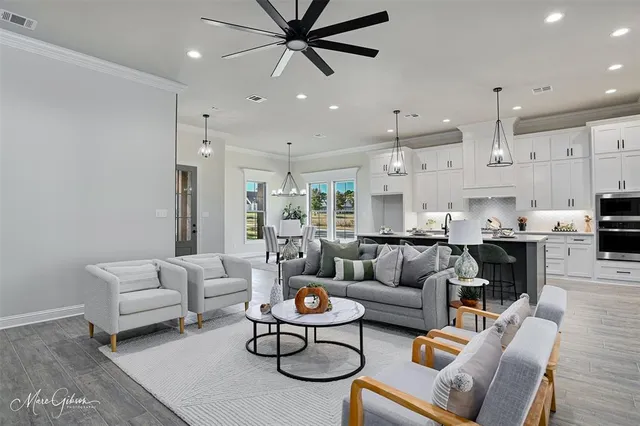 a living room with furniture kitchen view and a chandelier