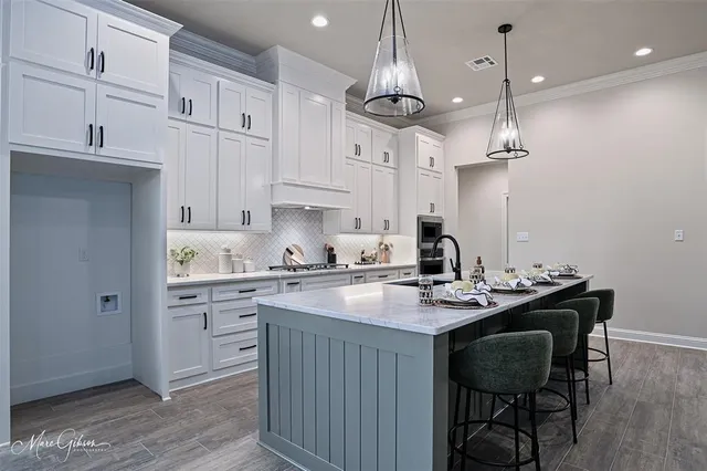 a kitchen with kitchen island granite countertop a sink a center island and cabinets