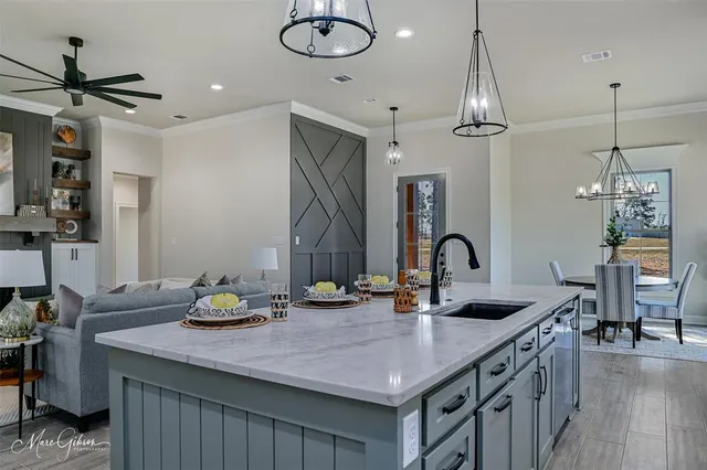 a kitchen with sink a chandelier and living room view