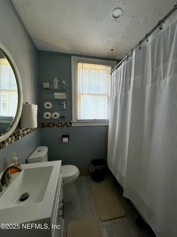 a bathroom with a sink a toilet and a mirror