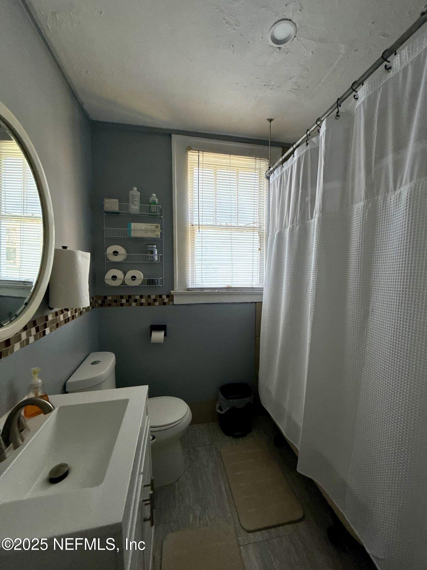 2850 Post Street Jacksonville, FL 32205 - Photo 4 of 20 a bathroom with a sink a toilet and a mirror