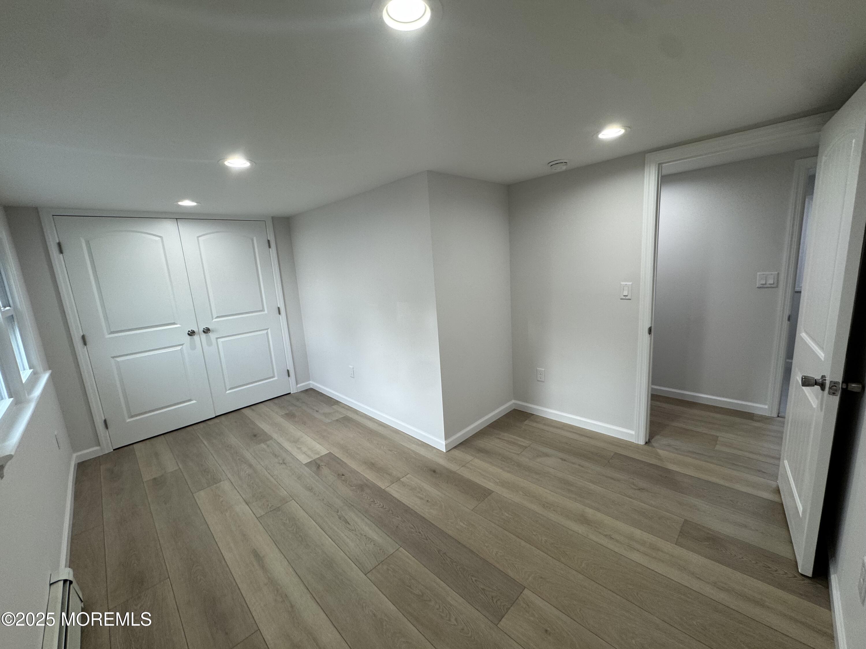 259 Matawan Avenue, Unit 2 Matawan, NJ 07747 - Photo 14 of 18 an empty room with wooden floor and windows