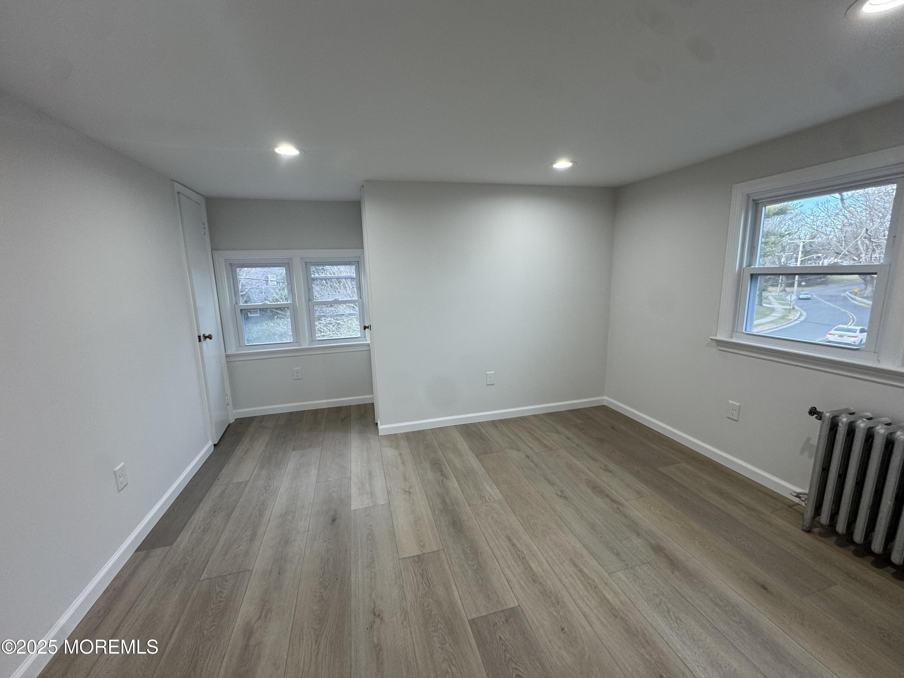 259 Matawan Avenue, Unit 2 Matawan, NJ 07747 - Photo 16 of 18 an empty room with wooden floor and windows